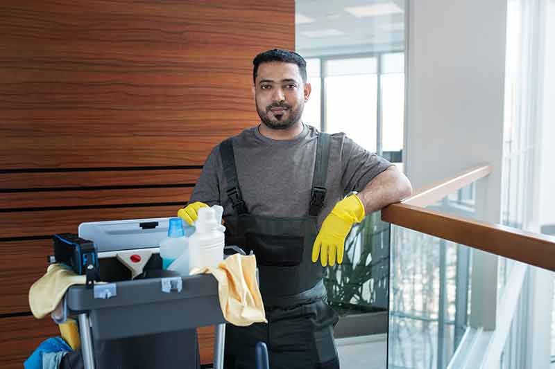 medium shot smiley man with cleaning cart